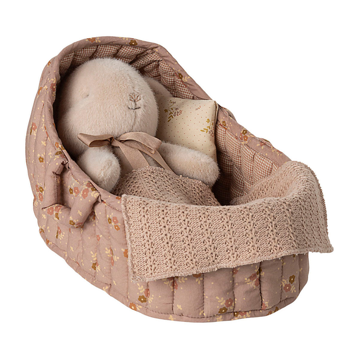 rose carrycot with a pillow and blanket with a rabbit in laying in it